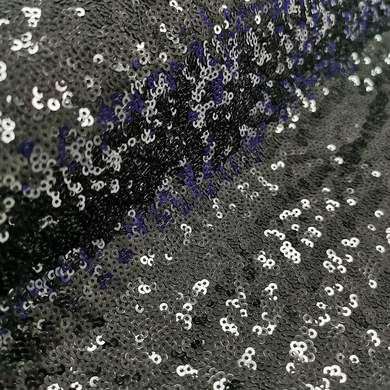 Tissu à paillettes (sequins) ronds cousus au milieu. Très brillant.