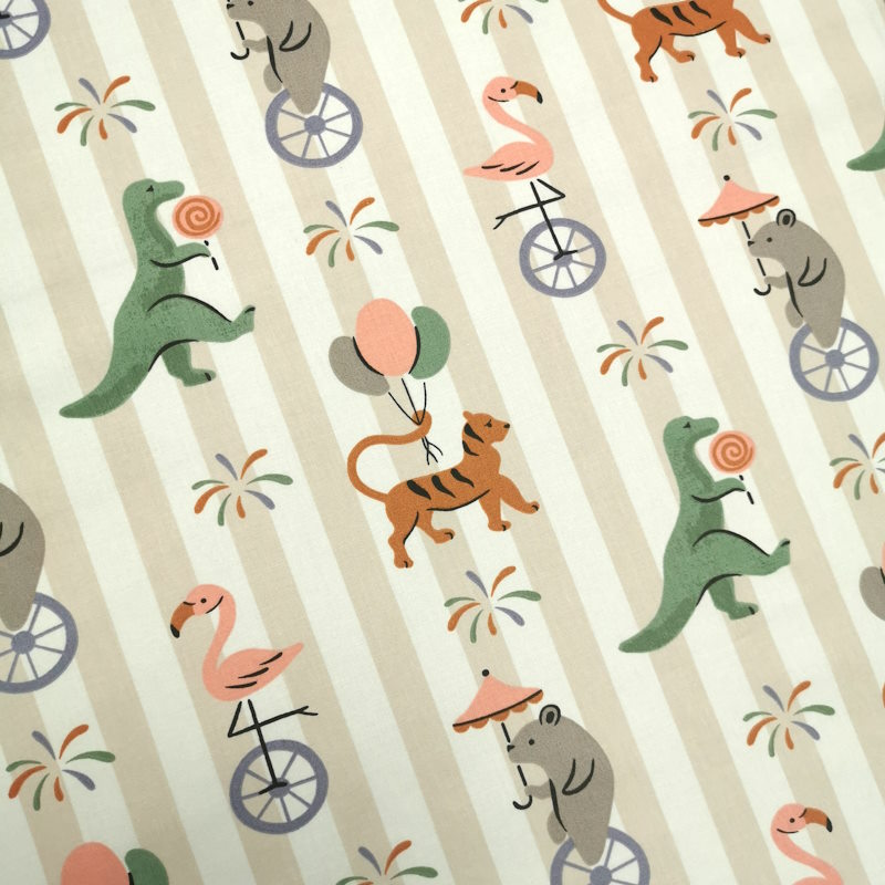 Animaux du cirque Tissu à rayure, avec par dessus des motifs d'animaux du cirque portant des ballons, des sucreries ou sur des monocycles.