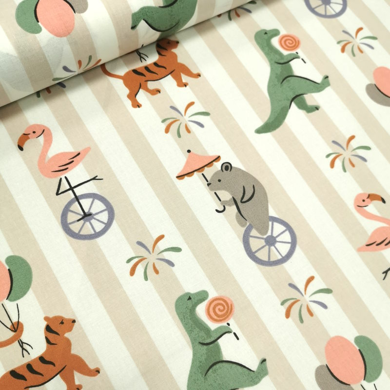 Animaux du cirque Tissu à rayure, avec par dessus des motifs d'animaux du cirque portant des ballons, des sucreries ou sur des monocycles.
