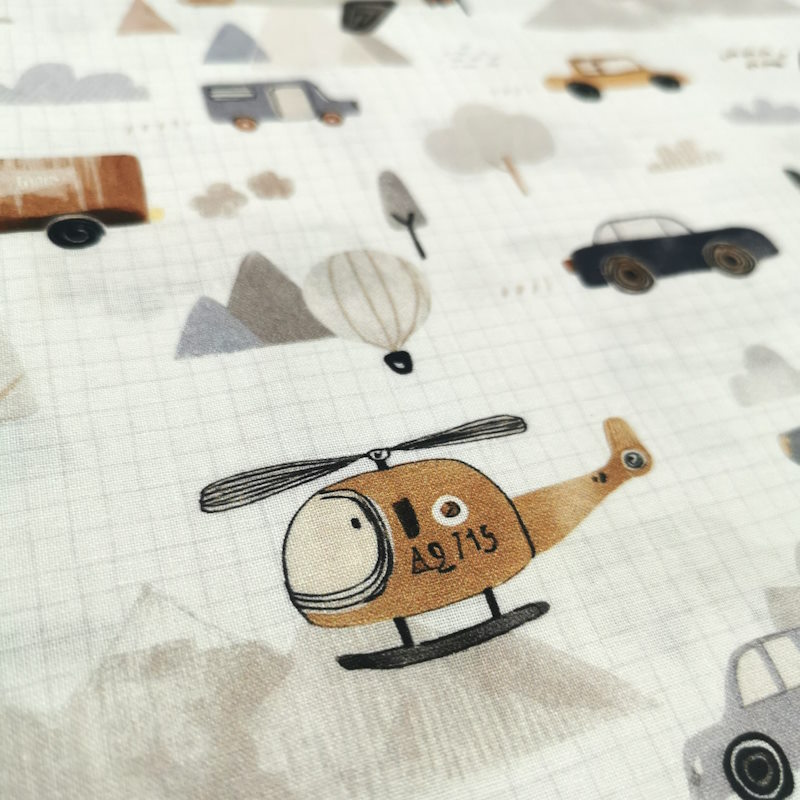 Hélicoptère tissu blanc avec un cadrillage comme une feuille de cahier, avec des motifs de camions; hélicoptère, voiture, montgolfière etc...