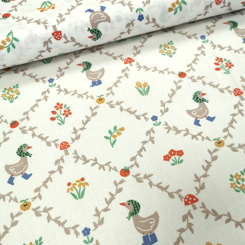 Petites Oies Tissu avec des motifs en quadrillage formant des losanges, avec au centre des petites oies mignonnes et des fleurs colorées.